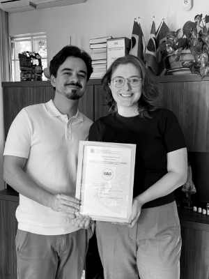 José Brognoli e uma cliente segurando juntos um certificado de registro de marca